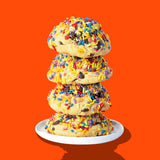 A stack of four Hunky Chunky Sunday Cookies, dark chocolate chips and rainbow sprinkles